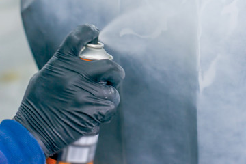 paint spray can in the hand of a worker