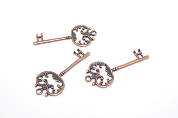 Vintage copper keys on white background close up
