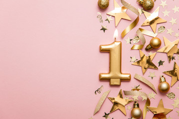Number 1 gold celebration candle on star and glitter background