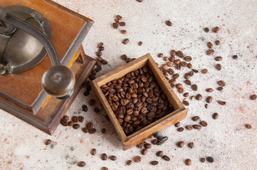 Old wooden coffee grinder on concrete background.