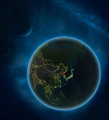 North Korea at night from space with Moon and Milky Way. Detailed planet Earth with city lights and visible country borders.