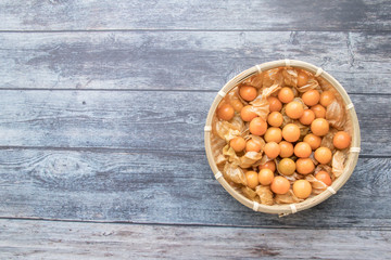 Cape gooseberry fruits in the basket (Physalis peruviana) on wooden background.Commonly called goldenberry, golden berry, Pichuberry.