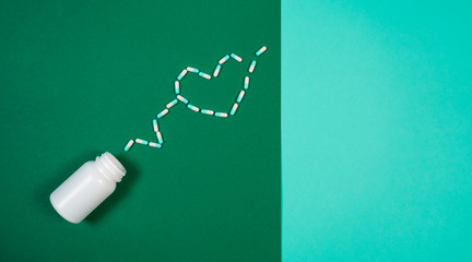 Pharmaceutical medicine pills, capsules on colored background.