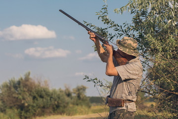 Hunters with a german drathaar and spaniel, pigeon hunting with dogs in reflective vests	