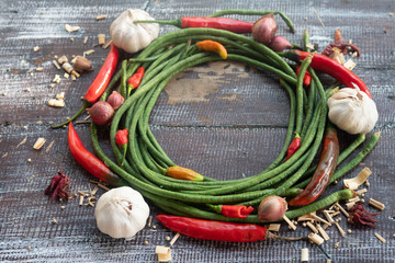 Fresh vegetables, chili, onion, garlic, herbs and spices.On a black wooden background. Free space for text . Top view