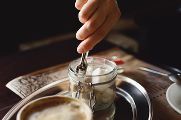 A woman takes sugar in a cafe. Close-up.