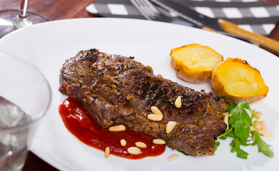 Beef steak with ketchup and pine nuts, served with  potatoe