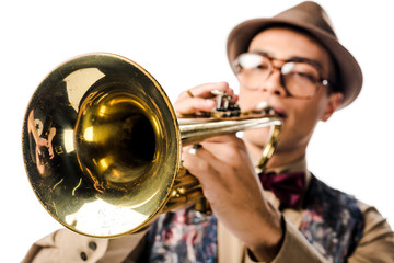 selective focus of mixed race male musician in stylish hat and eyeglasses playing on trumpet isolated on white © LIGHTFIELD STUDIOS