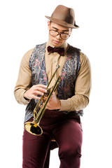 Naklejka premium young male jazzman holding trumpet and sitting on chair isolated on white