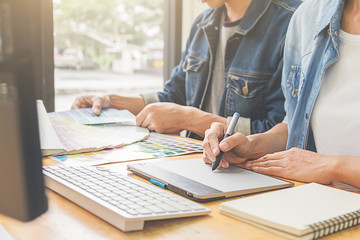 Graphic design with color swatches and tablet on a desk. Graphic designer drawing something on tablet at the office with work tools and accessories.