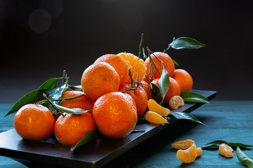 Clementines with leaves on a dark background .Fruits