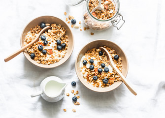 Homemade peanut butter granola with greek yogurt and blueberries on a light background, top view. Healthy energy breakfast or snack. Flat lay