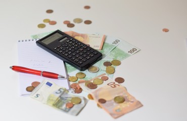 Euro-Geld Scheine und Münzen mit Taschenrechner, Notizblock und Stift