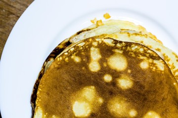 Fragrant pancakes that have just been cooked for a delicious breakfast. Pancakes lie on a white plate.