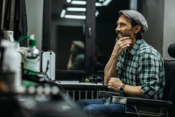 Happy man smiling and touching his beautiful beard
