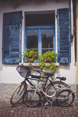 Fototapeta na wymiar Bike placed under a window full of flowers