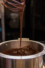 Iron bowl with dough in which the whisk mix the ingredients