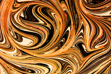 Orange, white and black paint mixing together creating lines pattern background.