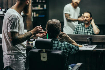 Man touching his hair while professional barber working