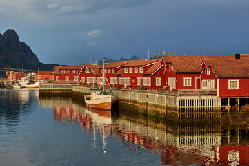 Fototapeta na wymiar Fishing village and ships at sunset. Lofoten Islands Travel. Norwegian nature. Scandinavian trip