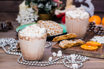 Hot cocoa with marshmallows and cinnamon in glasses on the table in Christmas decorations