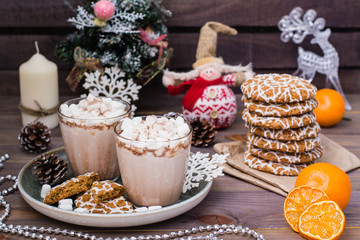 Hot cocoa with marshmallows in glasses and christmas cookies on the wooden table in Christmas decorations