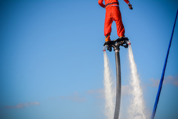 Horizontal View of Santa Claus on Flyboard on Blue Sky Background.