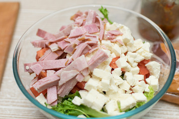 Cooking salad from fresh vegetables and cheese.