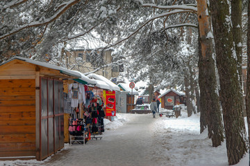 Naklejka premium Winter in the Zlatibor town. Street vendor selling tourist souvenirs and other little things. Popular tourist place on the same name mountain. Cloudy winter day.