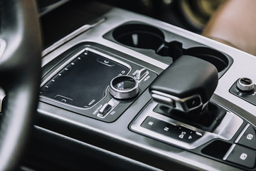 touch panel in a premium car. Management of multimedia functions, and options of the car, navigation, music. Cup holders and gear lever.