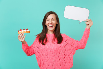 Laughing young woman in knitted pink sweater holding eclair cake, empty blank Say cloud speech...