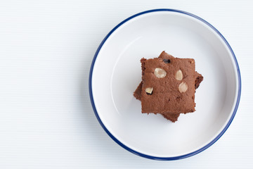 Homemade chocolate brownies topping with almond slices in white bowl