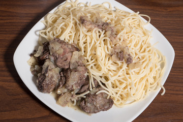 fried chicken liver with spaghetti in a white plate close-up top view