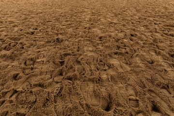  texture of brown sand and traces of human shoes