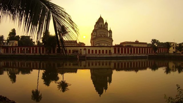 Beautiful sunset near Dakshineswar temple ponds reflection in mirror surface of water palms Ramakrishna mission