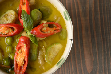 Thai food, green curry chicken with coconut curry on a wooden table