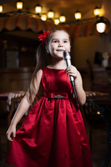 The girl with the microphone. A small child sings karaoke