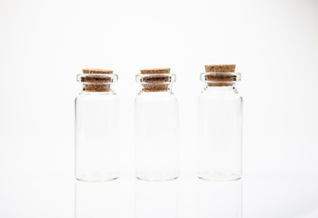 Empty little bottles with cork stopper on white background