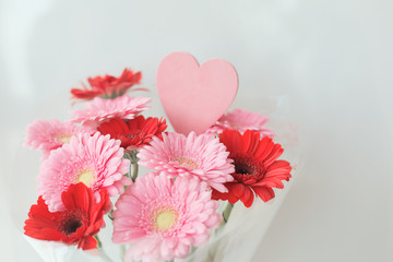 Bouquet of gerberas and a heart on a white background