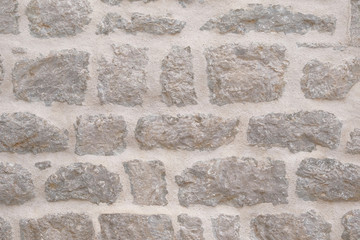 Light colour old stone wall texture. Ancient brick beige wall. Retro stone background.
