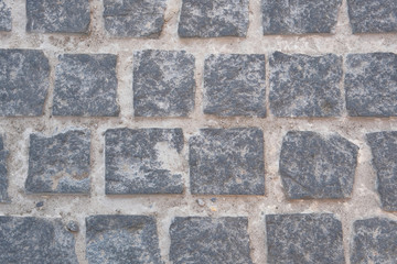 Pavement is lined with old stone. Gray retro stone texture. Ancient brick.