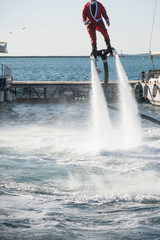 Vertical View of Santa Claus on Flyboard on Blue Sky Background. Taranto, Italy