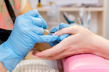 Manicure, cleaning, polishing and painting nails in the salon