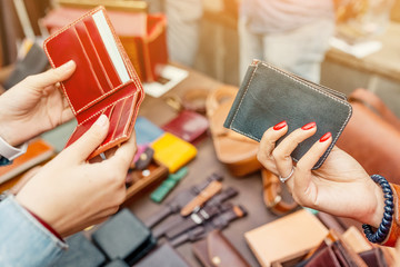 Woman choose to buy handmade leather wallet at street market