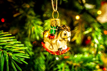 Small orcking horse, bauble on Christmas tree. Xmas decoration.
