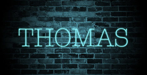 first name Thomas in blue neon on brick wall