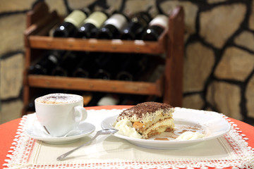 Naklejka na ściany i meble Tiramisu z kawą cappucino na stoliku, wino.