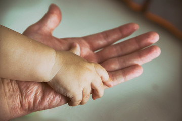 the child's hand in the parent's hand