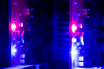 Equipment For Mining Crypto Bitcoin Token, Etherium Cash Close-up. Electronic Boards And Chips, Blue And Red Lights. Blurred Server Lights