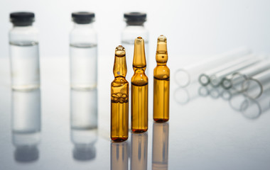 Group of vials with medication on blue methacrylate table.